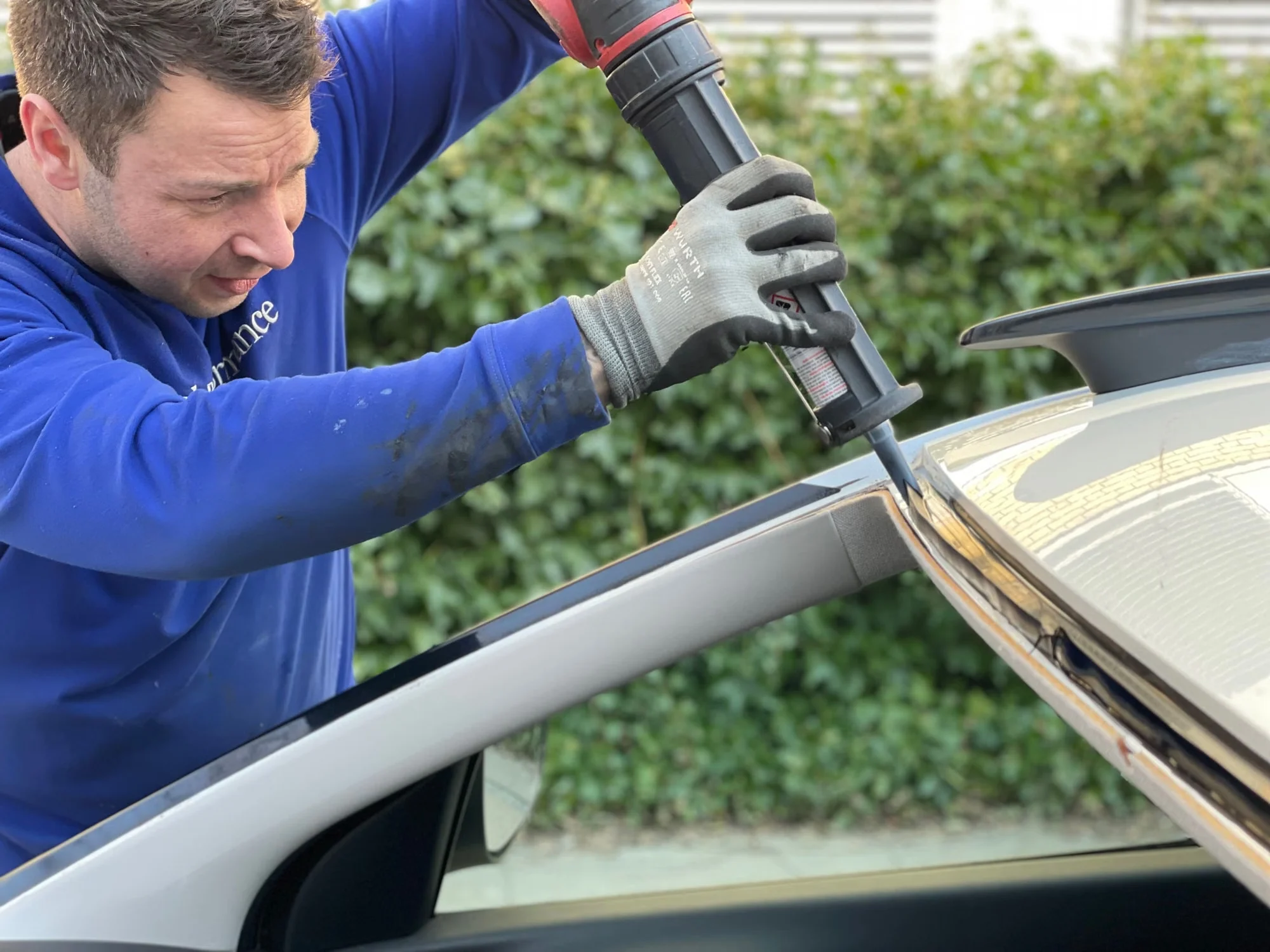 Technician preparing a car for windshield replacement